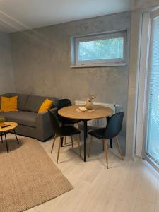 a living room with a couch and a table and chairs at Maja apartman in Dunajská Streda