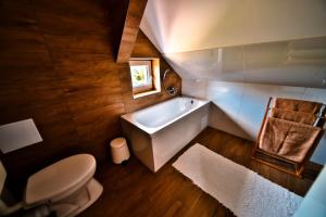 a bathroom with a toilet and a bath tub at Kriszta Deluxe Vendégház in Újfehértó