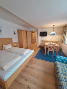 a bedroom with a bed and a dining room at Hotel Rauscher und Paracelsus in Bad Hofgastein