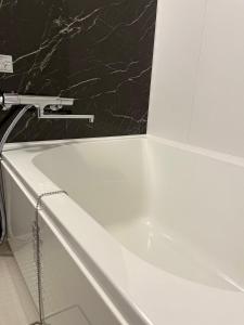 a white bath tub with a faucet in a bathroom at Seiryu Tsutenkaku in Osaka