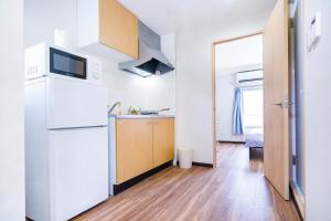 uma pequena cozinha com um frigorífico e um lavatório em 10min walk to Shinjuku EoY5 em Tóquio