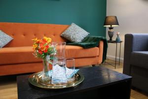 a table with a vase of flowers and glasses on it at Stylish townhouse-Central location-Great discoun s in Milton Keynes