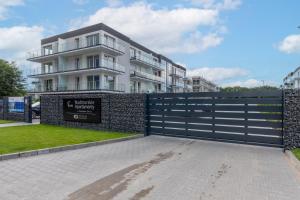 una puerta frente a un edificio con una valla en Apartamenty Nadbrzeżna 250 m do Plaży by Renters en Gąski