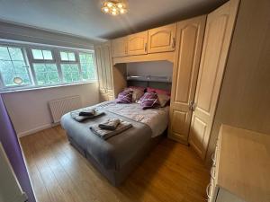 ein Schlafzimmer mit einem Bett mit zwei Handtüchern darauf in der Unterkunft Stylish townhouse-Sleeps 9-Free parking in Milton Keynes