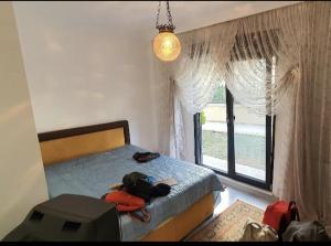 a bedroom with a bed with a backpack and a window at Albatros in Buyukcekmece