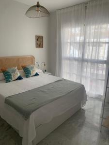 a bedroom with a large bed with a large window at Apartamento a un minuto playa in Fuengirola