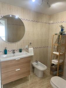 a bathroom with a sink and a toilet and a mirror at Apartamento a un minuto playa in Fuengirola