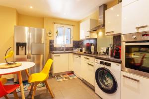 cocina con lavadora y mesa en ICONIC 2 AP4375 By Riviera Holiday Homes, en Niza