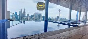 une piscine avec un horizon urbain en arrière-plan dans l'établissement The Colony Skyline Suites KLCC, à Kuala Lumpur