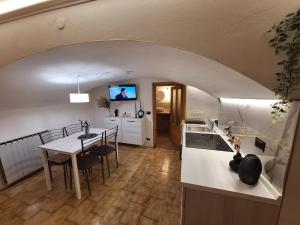 eine Küche und ein Esszimmer mit einem Tisch und einem TV in der Unterkunft La casa del Gigante Frassino in Acceglio