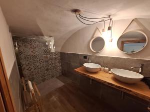 een badkamer met 2 wastafels en 2 spiegels bij La casa del Gigante Frassino in Acceglio