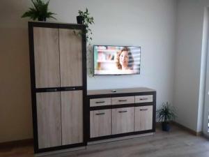 a tv on a wall in a room with a cabinet at Uniejów Apartament in Uniejow