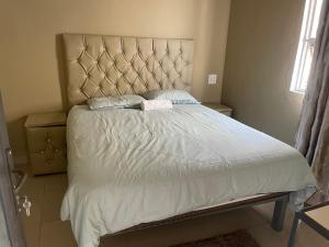 a bedroom with a large bed with a large headboard at Kang B&B in Mtubatuba
