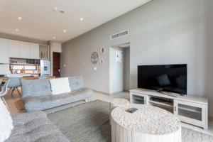 a living room with a couch and a flat screen tv at 602 Zimbali Suites, Ocean View in Ballito