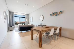 a dining room with a wooden table and chairs at 602 Zimbali Suites, Ocean View in Ballito