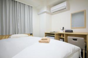ein Hotelzimmer mit zwei Betten und einem Schreibtisch in der Unterkunft Hotel Shin-Imamiya in Osaka + 111 Fotos