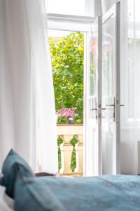 eine offene Tür mit einem Blumentopf auf dem Balkon in der Unterkunft Prague - Karlin Apartments in Prag
