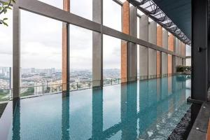 a swimming pool in the middle of a building with windows at Millerz Cozy Home by GUESTONIC in Kuala Lumpur