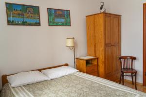 1 dormitorio con 1 cama y armario de madera en Kolory Guest House, en Cracovia