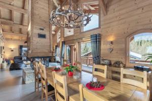 a dining room with a large wooden table and chairs at Chalet Carnauba in Châtel
