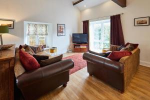un salon avec deux canapés et une télévision dans l'établissement Host & Stay - River View Cottage, à Barnard Castle