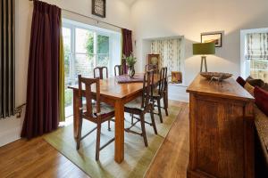 een eetkamer met een houten tafel en stoelen bij Host & Stay - River View Cottage in Barnard Castle