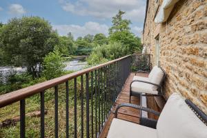 a balcony with two chairs and a river at Host & Stay - River View Cottage in Barnard Castle