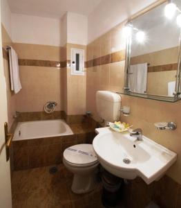 a bathroom with a sink and a toilet and a tub at Hotel Marily in Pyrgos