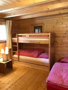 a bedroom with two bunk beds in a log cabin at Chalet with style in the beautiful Val Ferret in Praz-de-Fort