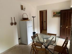 kuchnia ze szklanym stołem i krzesłami oraz lodówką w obiekcie Il Mulino Del Tempo Perduto w mieście Bagnone