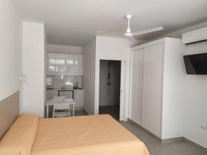 a white bedroom with a bed and a kitchen at Carihuela Beach Apartamentos in Torremolinos