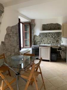 uma cozinha com uma mesa e cadeiras e uma parede de pedra em Il Mulino Del Tempo Perduto em Bagnone