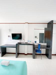 a desk with a blue chair in a room at Tanatnan Hotel in Ranong