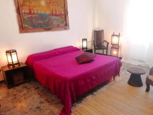 ein Schlafzimmer mit einem Bett mit einer rosa Decke in der Unterkunft Il Rifugio delle Rondini in Muravera