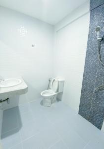 La salle de bains est pourvue de toilettes, d'un lavabo et d'une douche. dans l'établissement Tanatnan Hotel, à Ranong