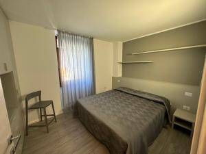 een slaapkamer met een bed en een stoel erin bij Appartamento Campagnola 10 in Riva del Garda
