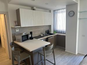 cocina con mesa con sillas y microondas en Appartamento Campagnola 10, en Riva del Garda