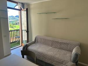 Una sala de estar con un sofá y un balcón. en Appartamento Campagnola 10, en Riva del Garda