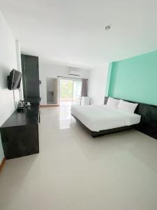 ein Schlafzimmer mit einem Bett und einem TV in der Unterkunft Tanatnan Hotel in Ranong