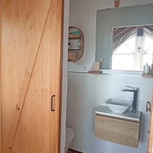 a bathroom with a sink and a toilet and a window at EL PALOMAR DE GÜERRES in Colunga