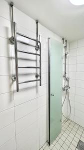 uma cabina de duche com uma porta de vidro na casa de banho em Paradise em Tampere