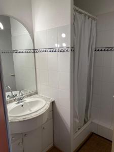 Un baño blanco con lavabo y ducha. en Appartement Résidence Fort Socoa, en Urrugne 4 fotos más
