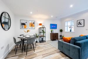 a living room with a blue couch and a table at Hosta Group - Prestige 1 Bed Apartment - The Orange in Cambridge