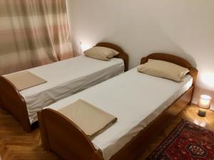 two twin beds in a room with a rug at Guest House Gaj Sarajevo in Sarajevo