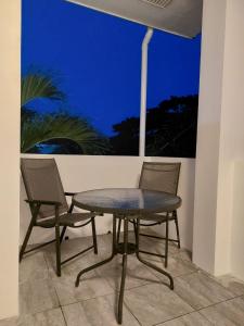 Bonsai Jacuzzi Suites في بنغلاو: طاولة وكرسيين على الفناء في الليل