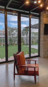 ブンタウにあるC House Villa Venuestayの大きな窓のある部屋(木製椅子付)