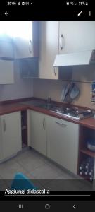 a kitchen with white cabinets and a sink at Amelia in Menton