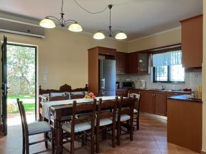 a kitchen with a wooden table and chairs and a kitchen with a table at Villa Artemis Vryses Crete in Alikampos