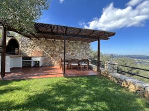 a patio with a table and chairs under a roof at Villa Artemis Vryses Crete in Alikampos