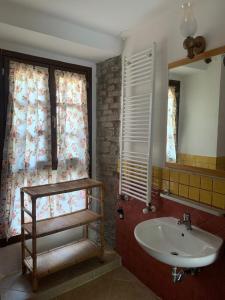 baño con lavabo y ventana en Il Mulino Del Tempo Perduto, en Bagnone